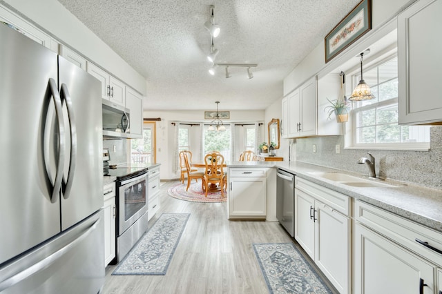 202 N Harper Ave, Springfield, MO 65802 - kitchen featuring appliances with stainless steel finishes, light wood-style flooring, white cabinets, light countertops, and a textured ceiling