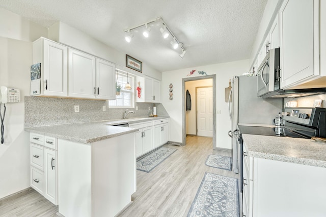 202 N Harper Ave, Springfield, MO 65802 - kitchen featuring stainless steel appliances, white cabinets, light wood-style flooring, light countertops, and backsplash