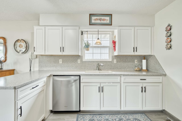 202 N Harper Ave, Springfield, MO 65802 - kitchen featuring dishwasher, white cabinetry, a textured ceiling, backsplash, and light wood-type flooring