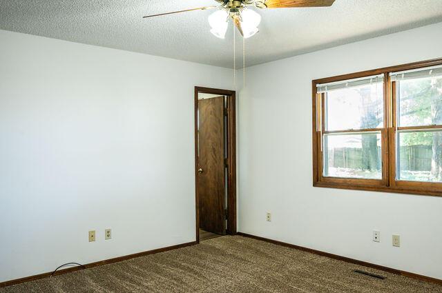 2812 W Maplewood St, Springfield, MO 65807 - spare room with a ceiling fan, carpet floors, and a textured ceiling