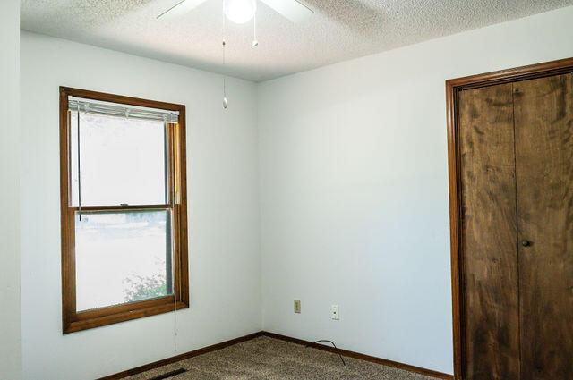 2812 W Maplewood St, Springfield, MO 65807 - empty room featuring carpet floors, a ceiling fan, and a textured ceiling