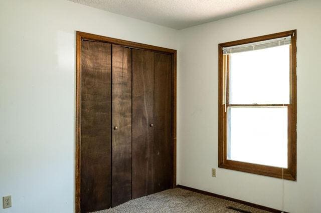 2812 W Maplewood St, Springfield, MO 65807 - unfurnished bedroom with carpet, a closet, and a textured ceiling