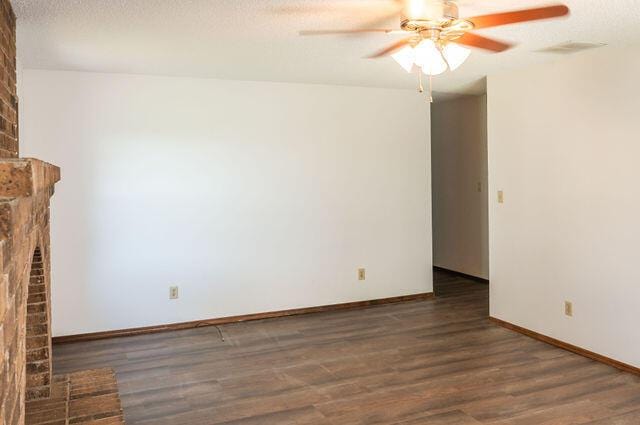 2812 W Maplewood St, Springfield, MO 65807 - unfurnished living room featuring ceiling fan, a brick fireplace, wood finished floors, and a textured ceiling