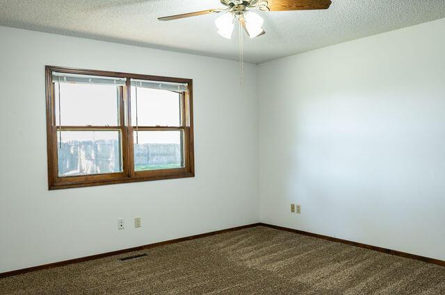 2812 W Maplewood St, Springfield, MO 65807 - unfurnished room with ceiling fan, a textured ceiling, and carpet