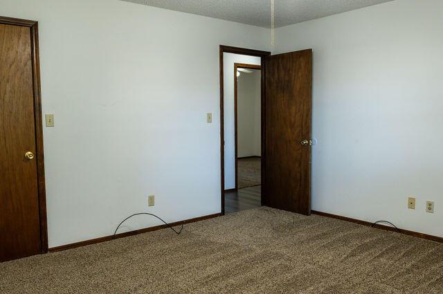 2812 W Maplewood St, Springfield, MO 65807 - carpeted spare room featuring baseboards and a textured ceiling