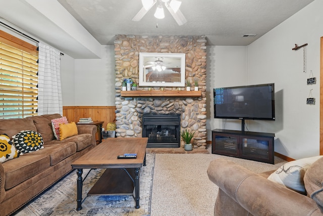 109 Grand Mountain Ave Unit 39-1, Branson, MO 65616 - living room with ceiling fan, a wainscoted wall, a stone fireplace, a textured ceiling, and wooden walls
