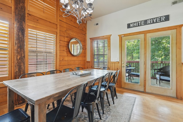 109 Grand Mountain Ave Unit 39-1, Branson, MO 65616 - dining room featuring wood walls, a chandelier, light wood-style flooring, and a towering ceiling