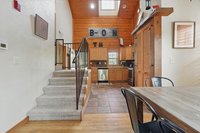 109 Grand Mountain Ave Unit 39-1, Branson, MO 65616 - kitchen featuring appliances with stainless steel finishes, a high ceiling, wooden walls, light wood-type flooring, and light brown cabinets
