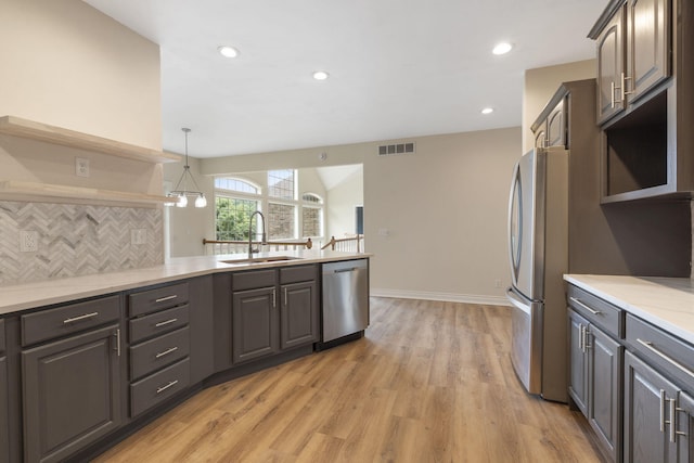 1007 Silvercrest Pl, Reeds Spring, MO 65737 - kitchen with appliances with stainless steel finishes, open shelves, light wood-type flooring, a peninsula, and backsplash
