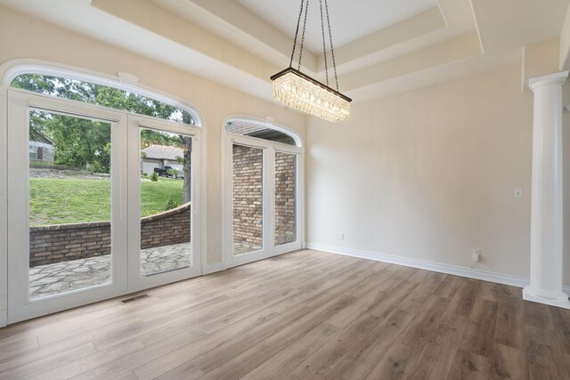 1007 Silvercrest Pl, Reeds Spring, MO 65737 - unfurnished dining area featuring ornate columns, a raised ceiling, wood finished floors, and a chandelier