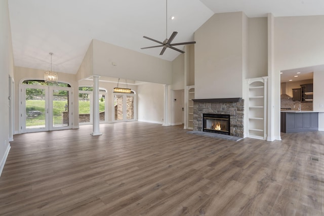 1007 Silvercrest Pl, Reeds Spring, MO 65737 - unfurnished living room with high vaulted ceiling, decorative columns, wood finished floors, a fireplace, and a ceiling fan