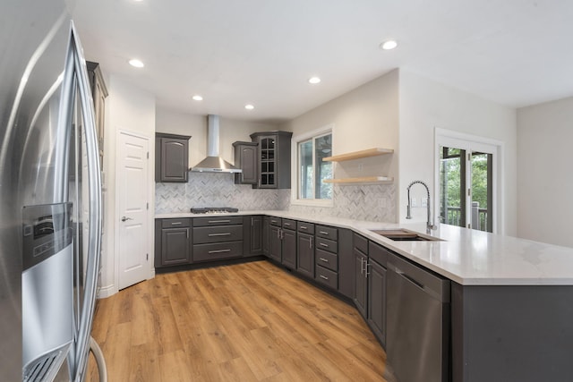 1007 Silvercrest Pl, Reeds Spring, MO 65737 - kitchen with stainless steel appliances, wall chimney range hood, a peninsula, light wood-style floors, and tasteful backsplash