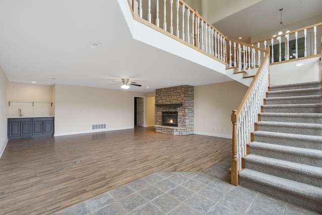 1007 Silvercrest Pl, Reeds Spring, MO 65737 - unfurnished living room featuring wood finished floors, ceiling fan, a fireplace, stairs, and recessed lighting