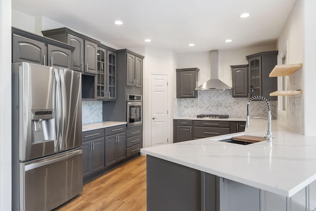 1007 Silvercrest Pl, Reeds Spring, MO 65737 - kitchen with appliances with stainless steel finishes, wall chimney exhaust hood, a peninsula, glass insert cabinets, and decorative backsplash