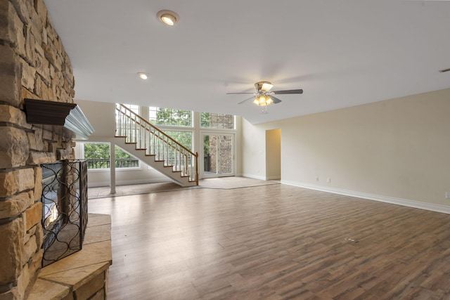 1007 Silvercrest Pl, Reeds Spring, MO 65737 - unfurnished living room with ceiling fan, a stone fireplace, wood finished floors, and stairs