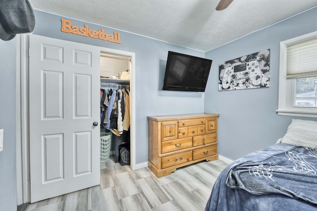 3153 W Washita St, Springfield, MO 65807 - bedroom with wood finished floors, a textured ceiling, a walk in closet, a closet, and ceiling fan