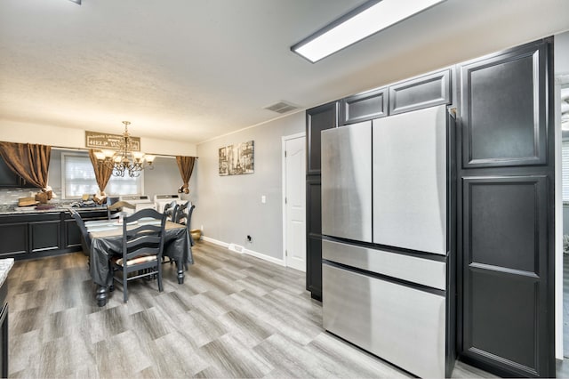 3153 W Washita St, Springfield, MO 65807 - kitchen with freestanding refrigerator, a chandelier, light wood finished floors, and decorative light fixtures