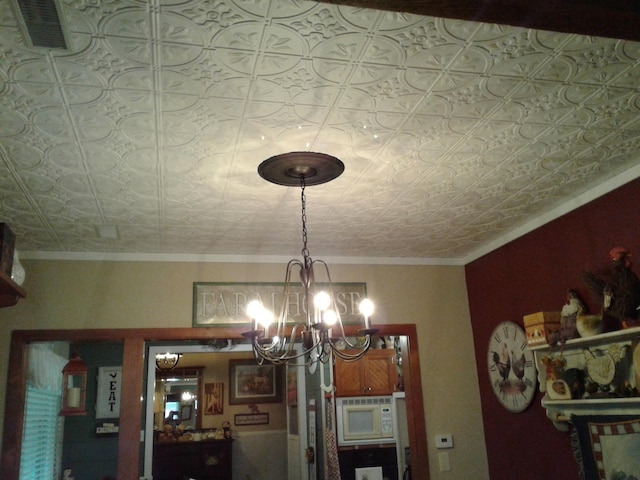 701 Spears Ave, Crane, MO 65633 - detailed view of white microwave, a chandelier, an ornate ceiling, and crown molding