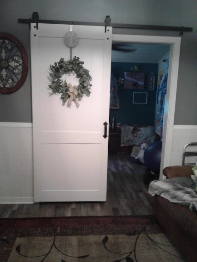 701 Spears Ave, Crane, MO 65633 - interior space featuring a barn door, wood finished floors, and a wainscoted wall