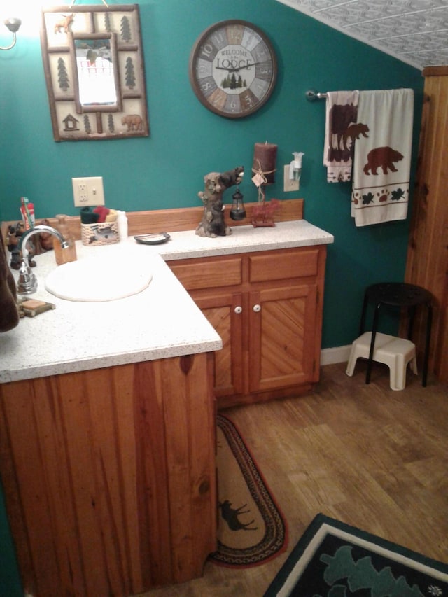 701 Spears Ave, Crane, MO 65633 - bathroom featuring vanity, wood finished floors, and lofted ceiling