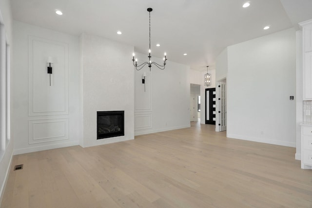 2124 N Silver Charm Ave, Springfield, MO 65802 - unfurnished living room with light wood-type flooring, a chandelier, recessed lighting, and a fireplace