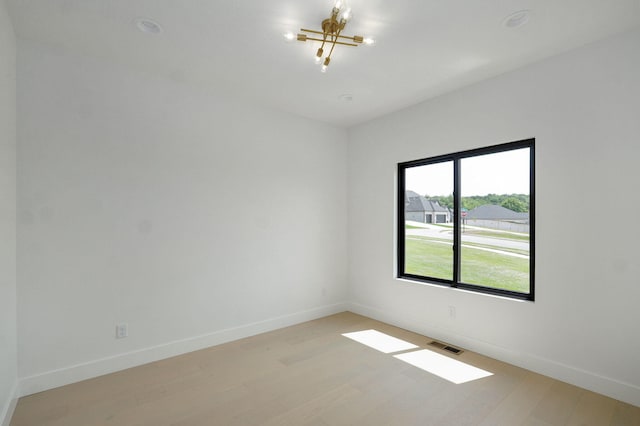 2124 N Silver Charm Ave, Springfield, MO 65802 - spare room featuring light wood-style flooring and a chandelier