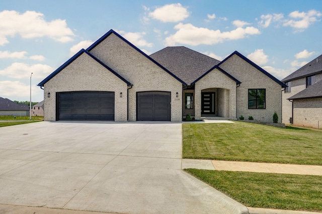2124 N Silver Charm Ave, Springfield, MO 65802 - french provincial home with a garage, concrete driveway, a front yard, and brick siding