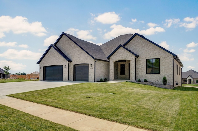 2124 N Silver Charm Ave, Springfield, MO 65802 - french country home featuring driveway, an attached garage, a front lawn, and brick siding