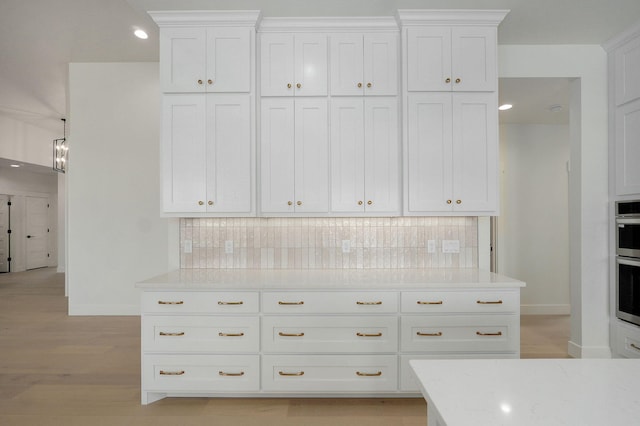 2124 N Silver Charm Ave, Springfield, MO 65802 - kitchen with decorative backsplash, white cabinets, light wood-style floors, light stone countertops, and recessed lighting