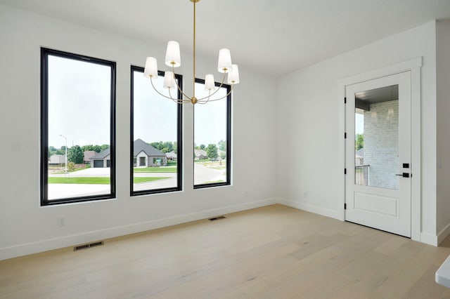 2124 N Silver Charm Ave, Springfield, MO 65802 - unfurnished dining area featuring a chandelier, plenty of natural light, and light wood-type flooring