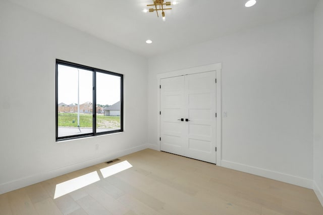 2124 N Silver Charm Ave, Springfield, MO 65802 - unfurnished bedroom with light wood-type flooring, recessed lighting, and a chandelier