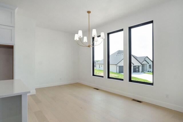 2124 N Silver Charm Ave, Springfield, MO 65802 - unfurnished dining area with light wood-style floors and a chandelier