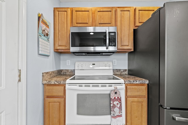 280 Quail Run Rd, Branson, MO 65616 - kitchen with appliances with stainless steel finishes, dark countertops, and brown cabinets