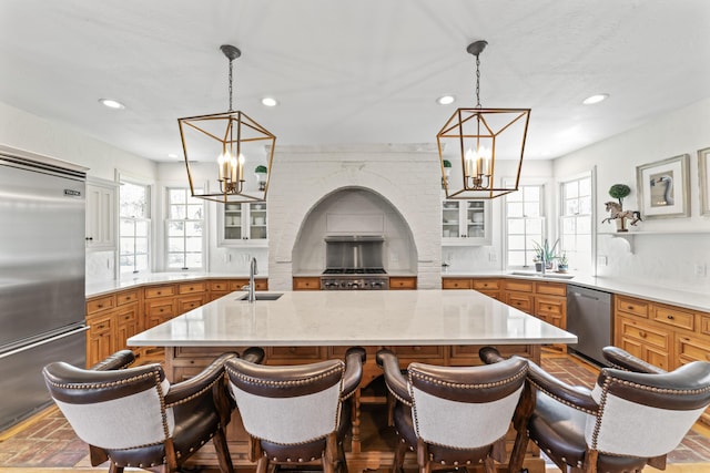 6420 E Turner Springs Rd, Springfield, MO 65809 - kitchen featuring appliances with stainless steel finishes, a chandelier, recessed lighting, glass insert cabinets, and brown cabinetry