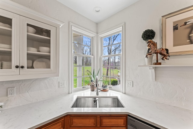 6420 E Turner Springs Rd, Springfield, MO 65809 - kitchen featuring brown cabinets, glass insert cabinets, backsplash, dishwashing machine, and light stone counters