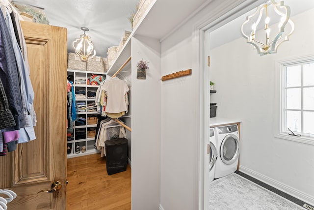 6420 E Turner Springs Rd, Springfield, MO 65809 - laundry area featuring washing machine and clothes dryer, a chandelier, and wood finished floors