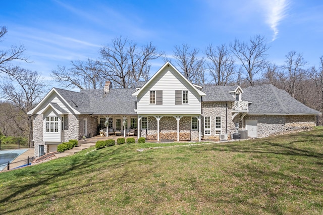 6420 E Turner Springs Rd, Springfield, MO 65809 - back of property with stone siding, a chimney, a lawn, and roof with shingles