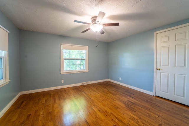 600 E Boone St, Ash Grove, MO 65604 - empty room with wood finished floors, ceiling fan, and a textured ceiling
