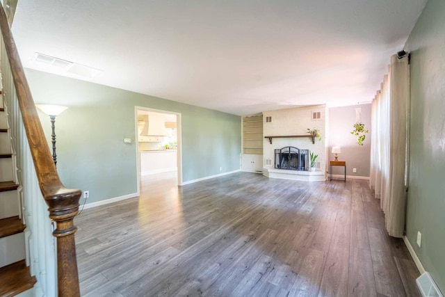 600 E Boone St, Ash Grove, MO 65604 - unfurnished living room featuring wood finished floors, stairs, and a large fireplace
