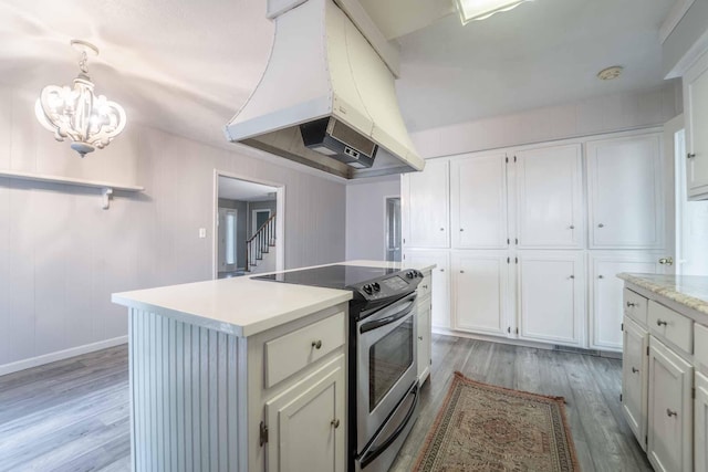 600 E Boone St, Ash Grove, MO 65604 - kitchen featuring stainless steel electric range, island range hood, light wood-style flooring, and white cabinetry