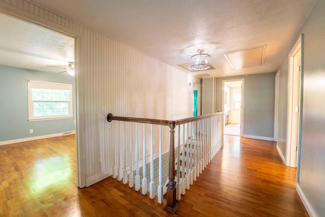 600 E Boone St, Ash Grove, MO 65604 - hallway featuring attic access, wood finished floors, an upstairs landing, and a textured ceiling