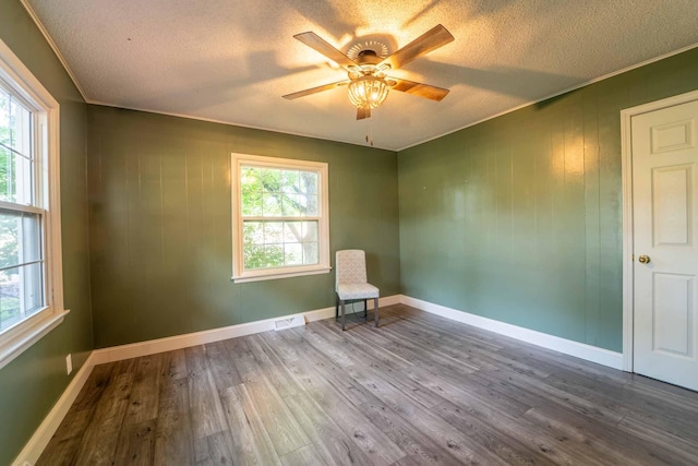 600 E Boone St, Ash Grove, MO 65604 - spare room with a textured ceiling, a ceiling fan, wood finished floors, and ornamental molding