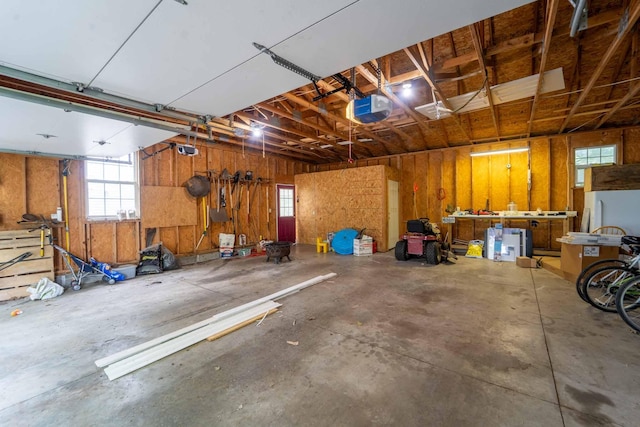 600 E Boone St, Ash Grove, MO 65604 - garage featuring a workshop area, a garage door opener, and freestanding refrigerator