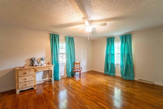600 E Boone St, Ash Grove, MO 65604 - spare room with a textured ceiling, a ceiling fan, and wood finished floors