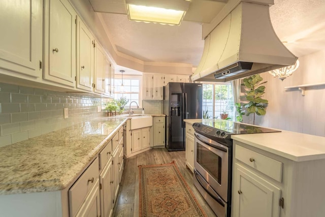 600 E Boone St, Ash Grove, MO 65604 - kitchen featuring stainless steel range with electric cooktop, island range hood, black fridge with ice dispenser, light countertops, and healthy amount of natural light