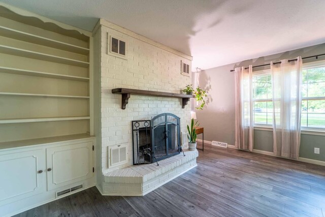 600 E Boone St, Ash Grove, MO 65604 - unfurnished living room with dark wood-style floors, a fireplace, and built in shelves