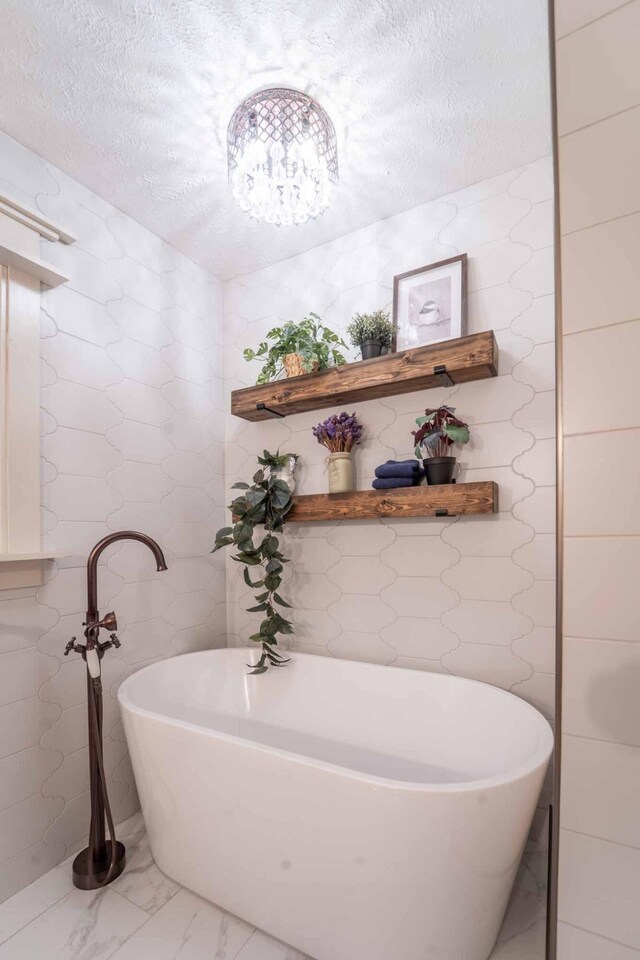 600 E Boone St, Ash Grove, MO 65604 - bathroom featuring a textured ceiling, a freestanding bath, and marble finish floors