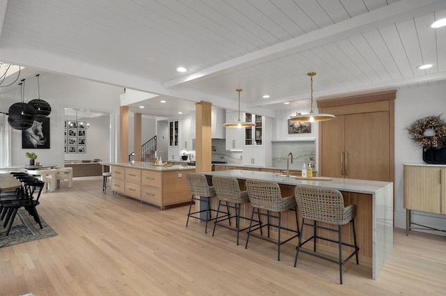 12451 State Highway 174, Billings, MO 65610 - kitchen with a large island with sink, a breakfast bar area, light wood finished floors, decorative backsplash, and recessed lighting