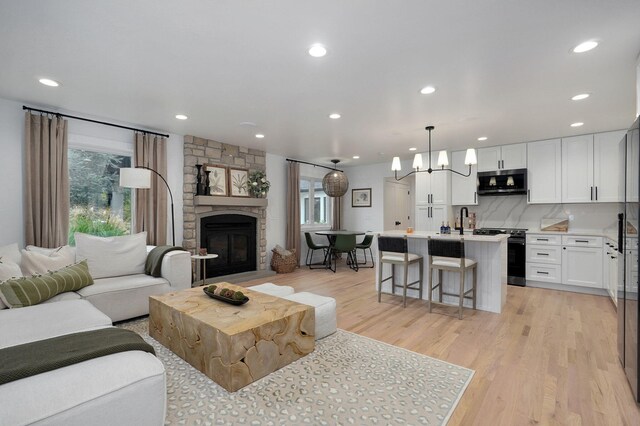 12451 State Highway 174, Billings, MO 65610 - living room featuring a fireplace, a chandelier, light wood-type flooring, and recessed lighting