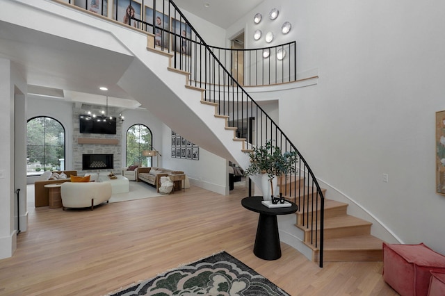 12451 State Highway 174, Billings, MO 65610 - stairway with wood finished floors, a towering ceiling, a fireplace, and a chandelier